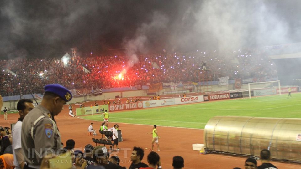 Penonton yang berada di salah satu tribun penonton menyalakan flare, dalam laga Persija Jakarta melawan Persib Bandung. Copyright: © Benny Rahardjo/INDOSPORT